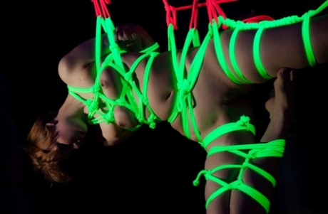 Completely naked female is suspended in the air by neon ropes 30942699