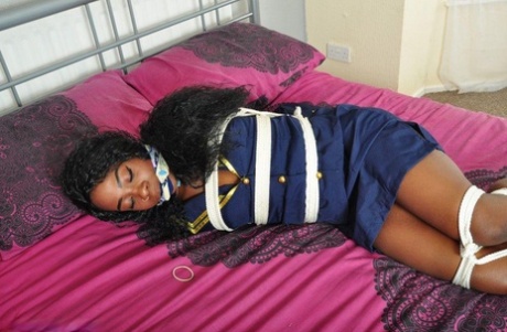 Ebony stewardess finds herself gagged and tied up on a bed in her uniform 50182849