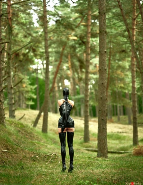 Rubber clad female is left stranded by herself in the forest 81841621