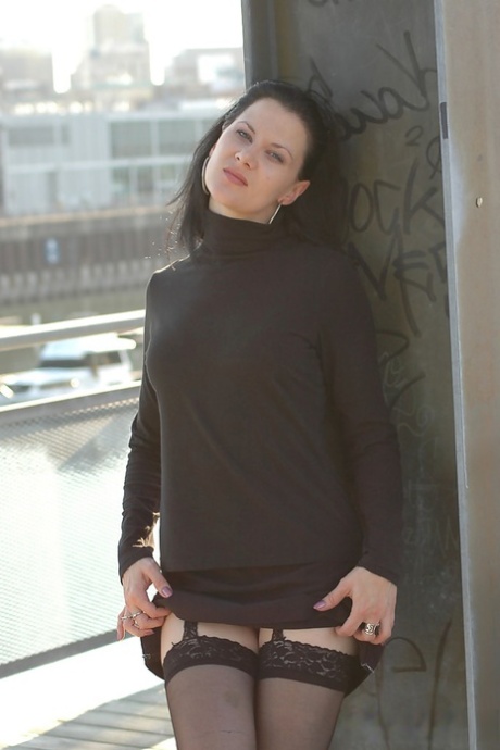 Black clad MILF in boots teases with naked upskirt on outdoor steps 82319144