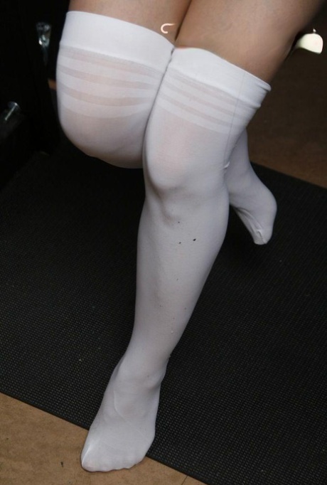 Caucasian female models white over the knee hosiery during a solo show 45992159