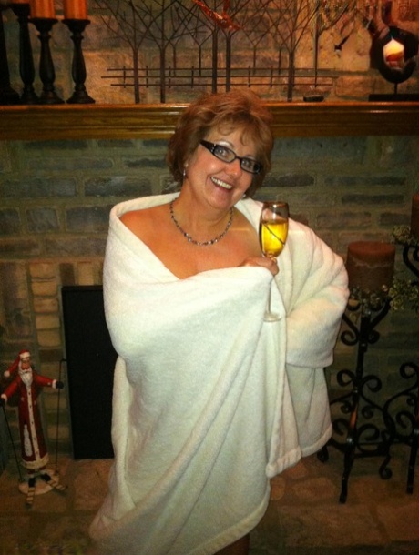 Mature lady with short hair Busty Bliss goes totally naked afore a fireplace 21367013