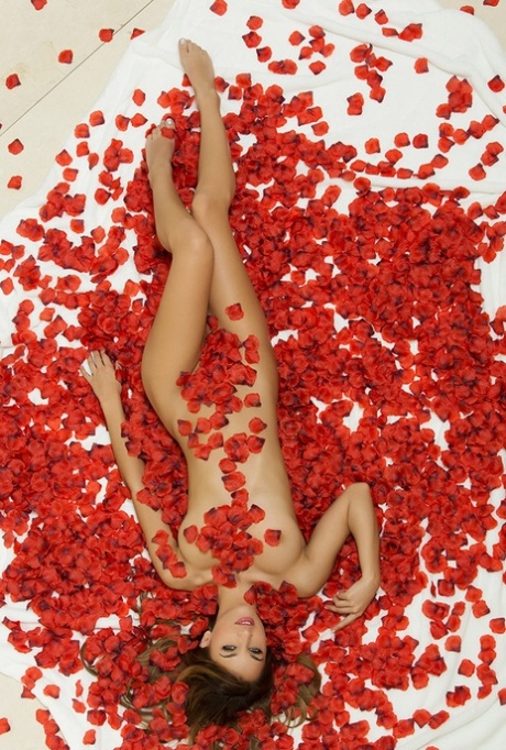 Beautiful girl Uma Jolie poses for a centerfold spread amid red rose petals 24303202