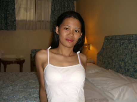 Slender Asian girl exposes a solitary boob while stripping to bra and thong 13955090